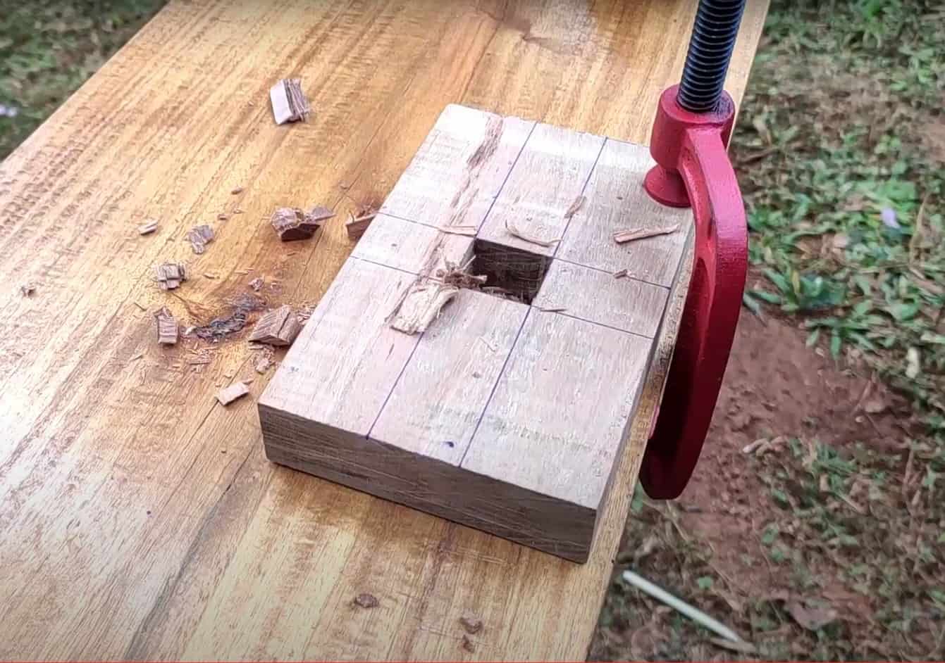 a wooden board with a square hole in the center lies on a wooden table