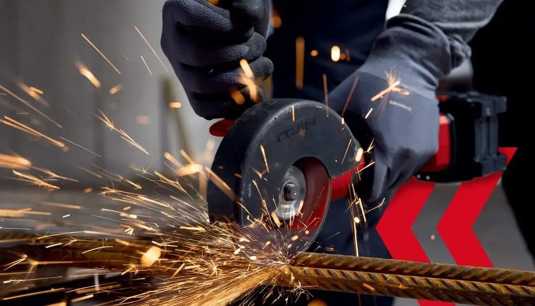 Angle grinder cuts metal rod and sparks fly
