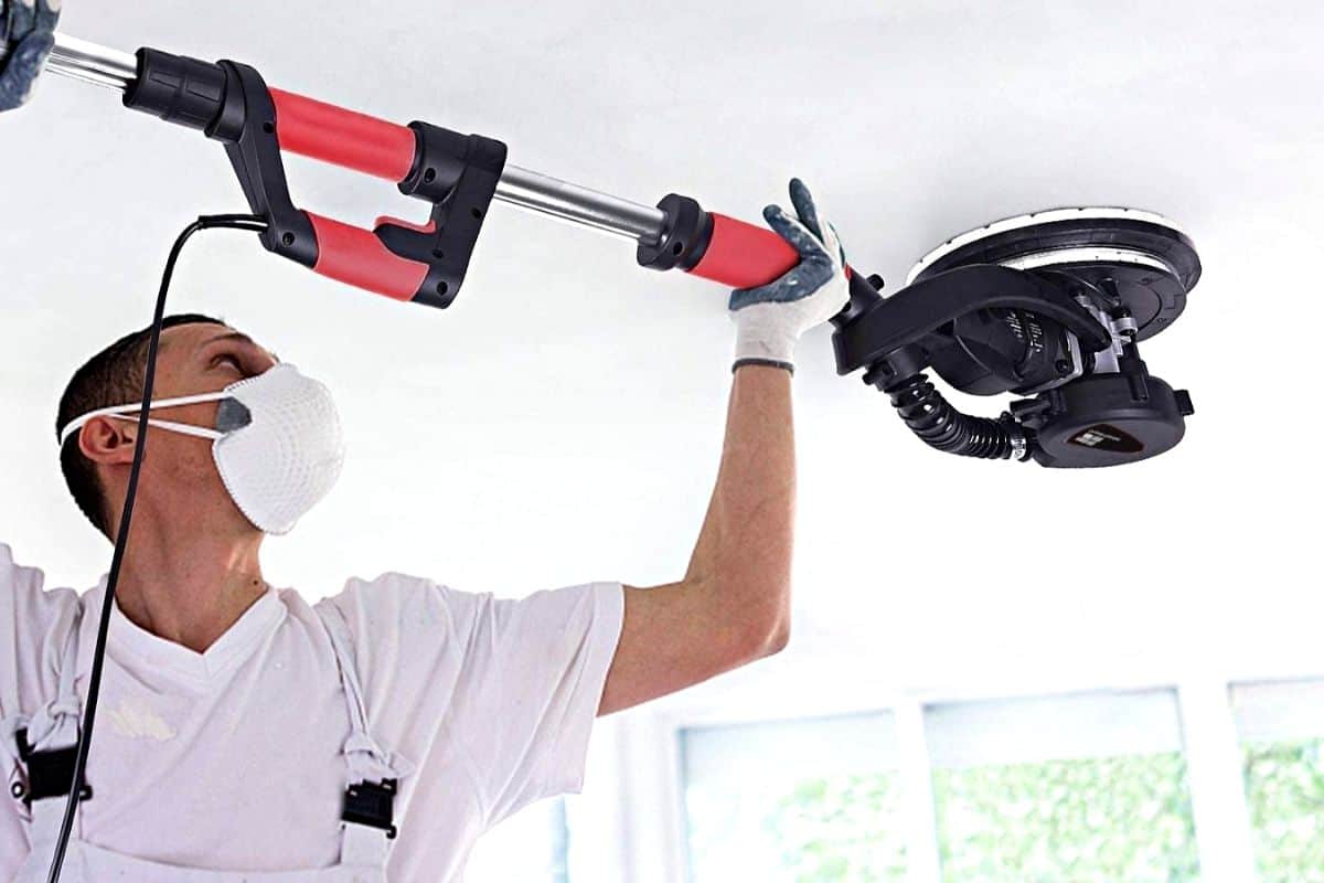 Working with an electric sander on a ceiling