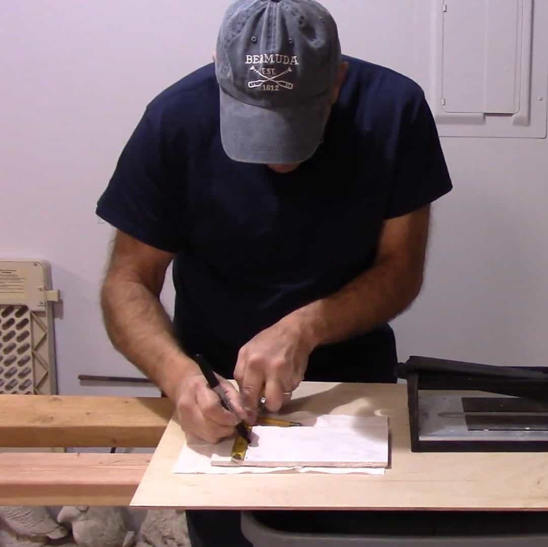 A man marks out a tile before cutting it